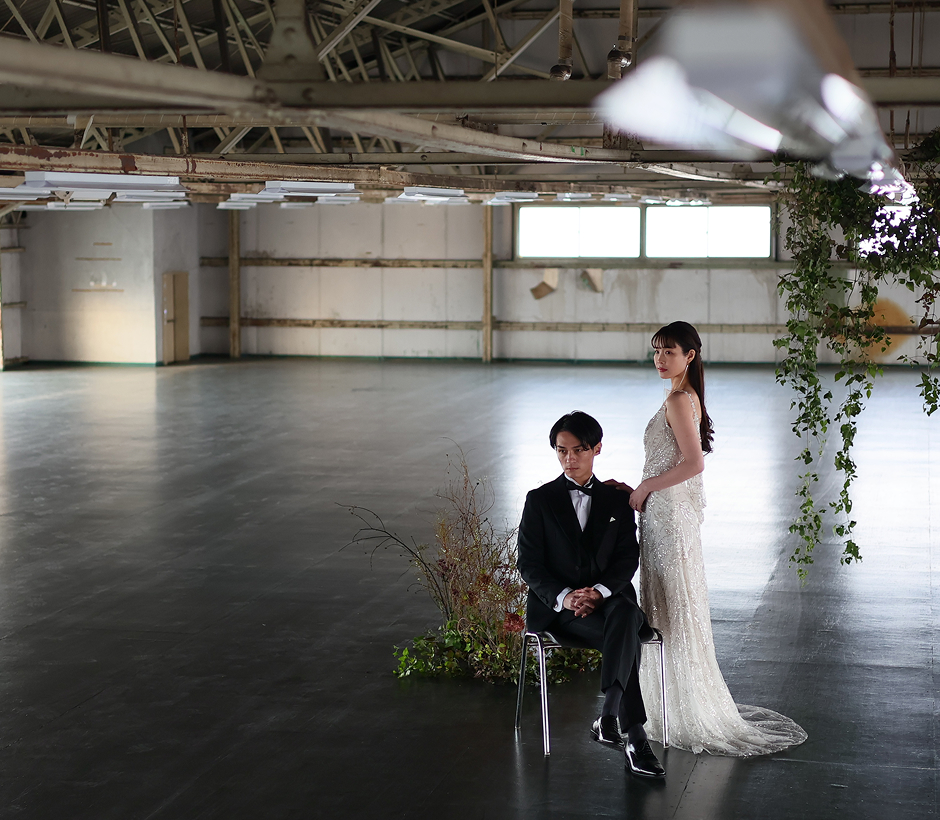 ウェディングドレス姿の花嫁とタキシード姿の新郎が室内で並ぶ様子